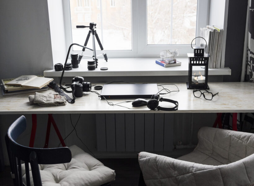 Desk with closed laptop and two chairs