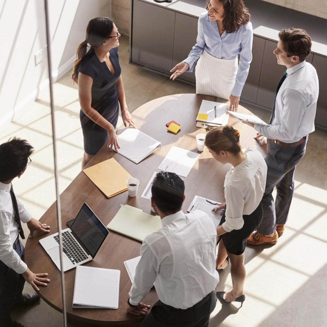 Female manager in team meeting, elevated view through window