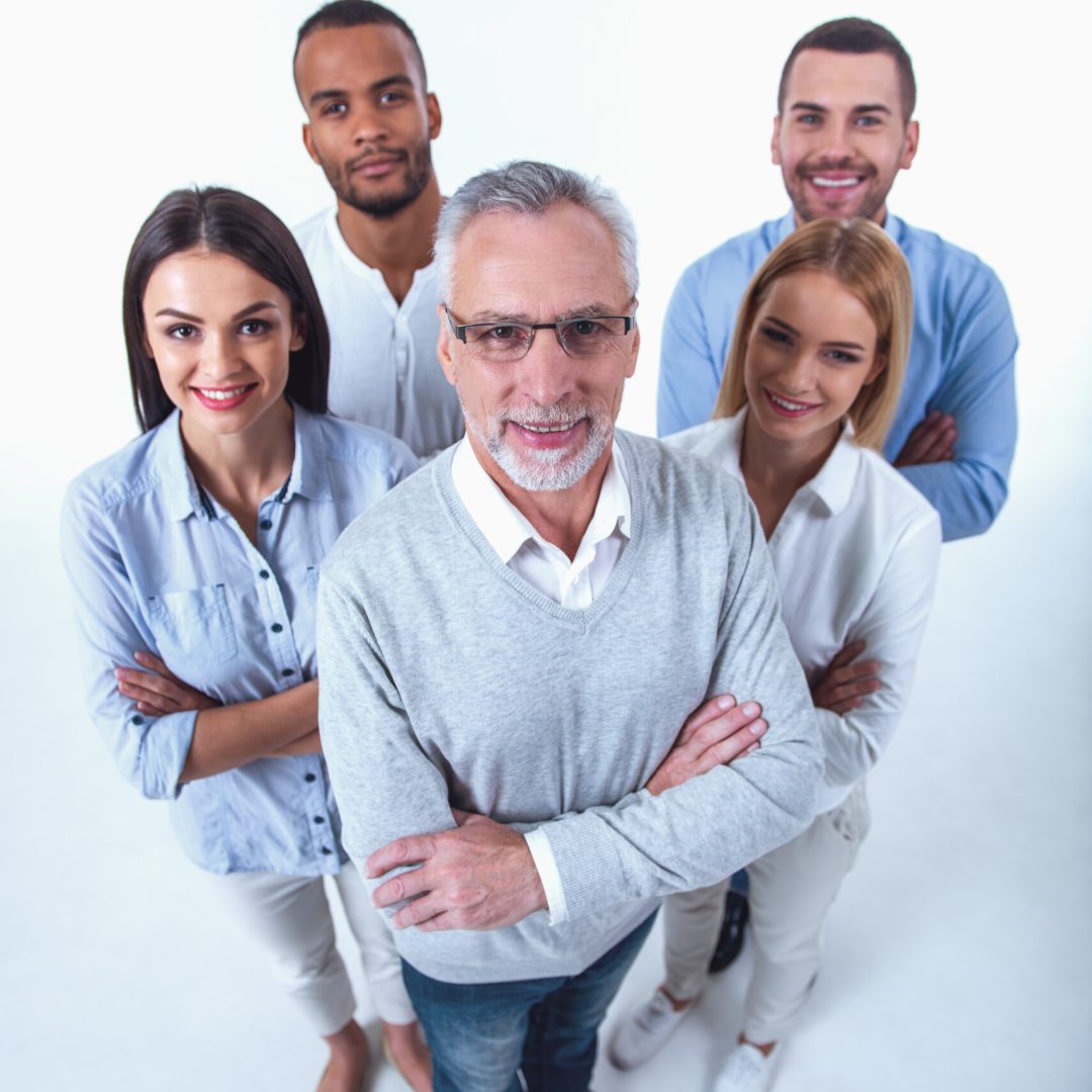 High angle view of beautiful business people in smart casual wear looking at camera and smiling while standing with folded arms on a white background